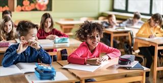 Large group of happy students attending a class at elementary school